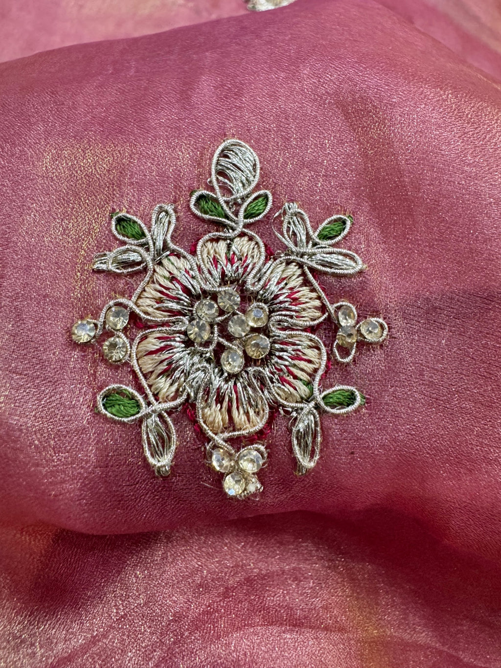 Decorative floral embroidery on a pink fabric background