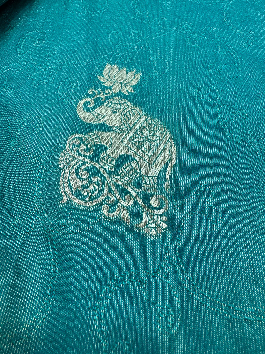 Teal fabric with intricate white elephant design