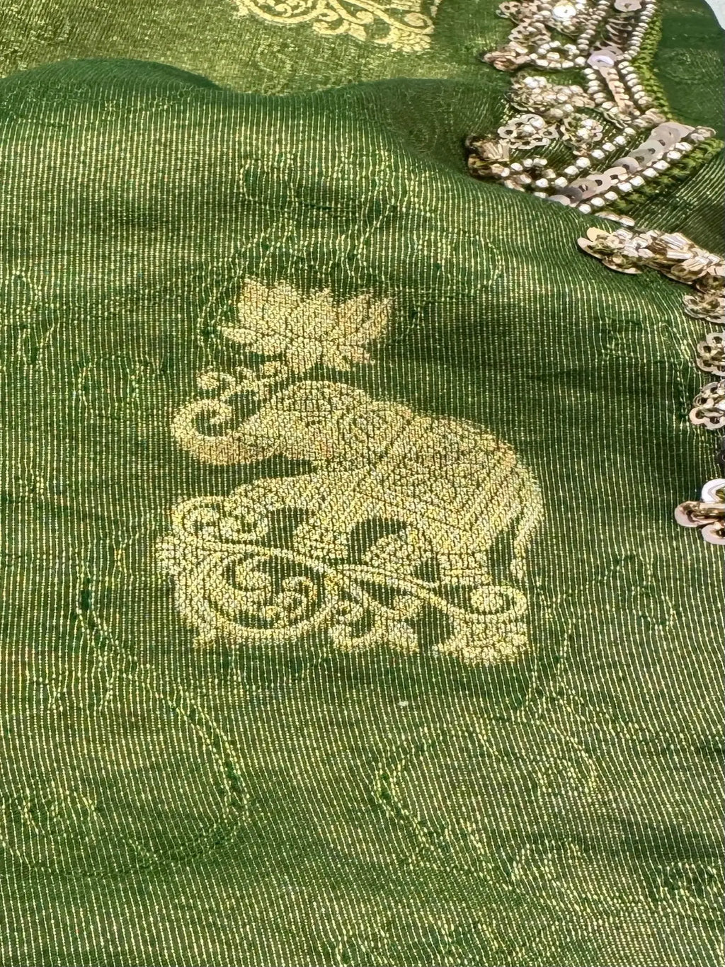 Green fabric with gold embroidery featuring an elephant design.