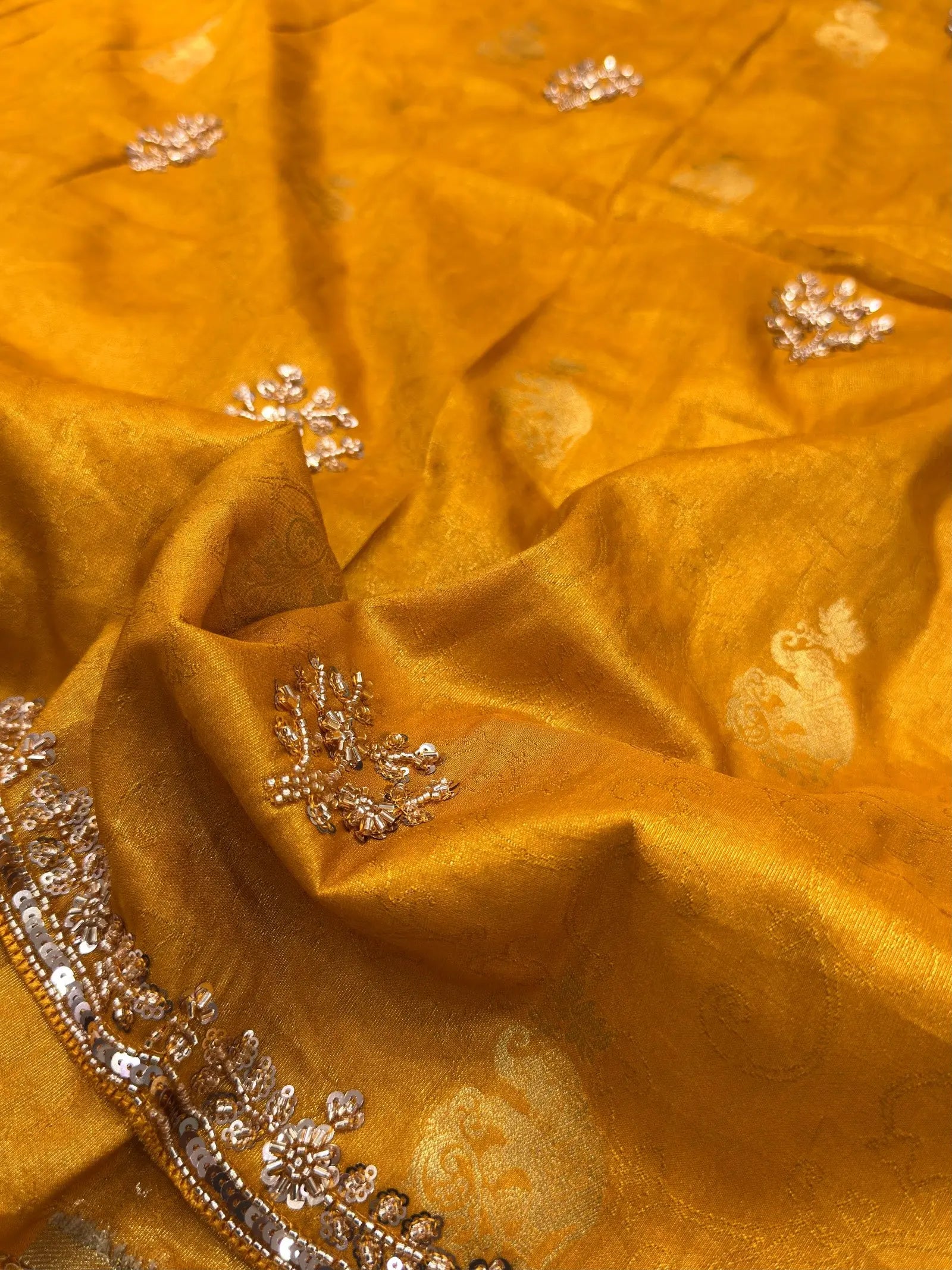 Textured view of mustard yellow Dolla silk saree with zari motifs and scattered handwork butti