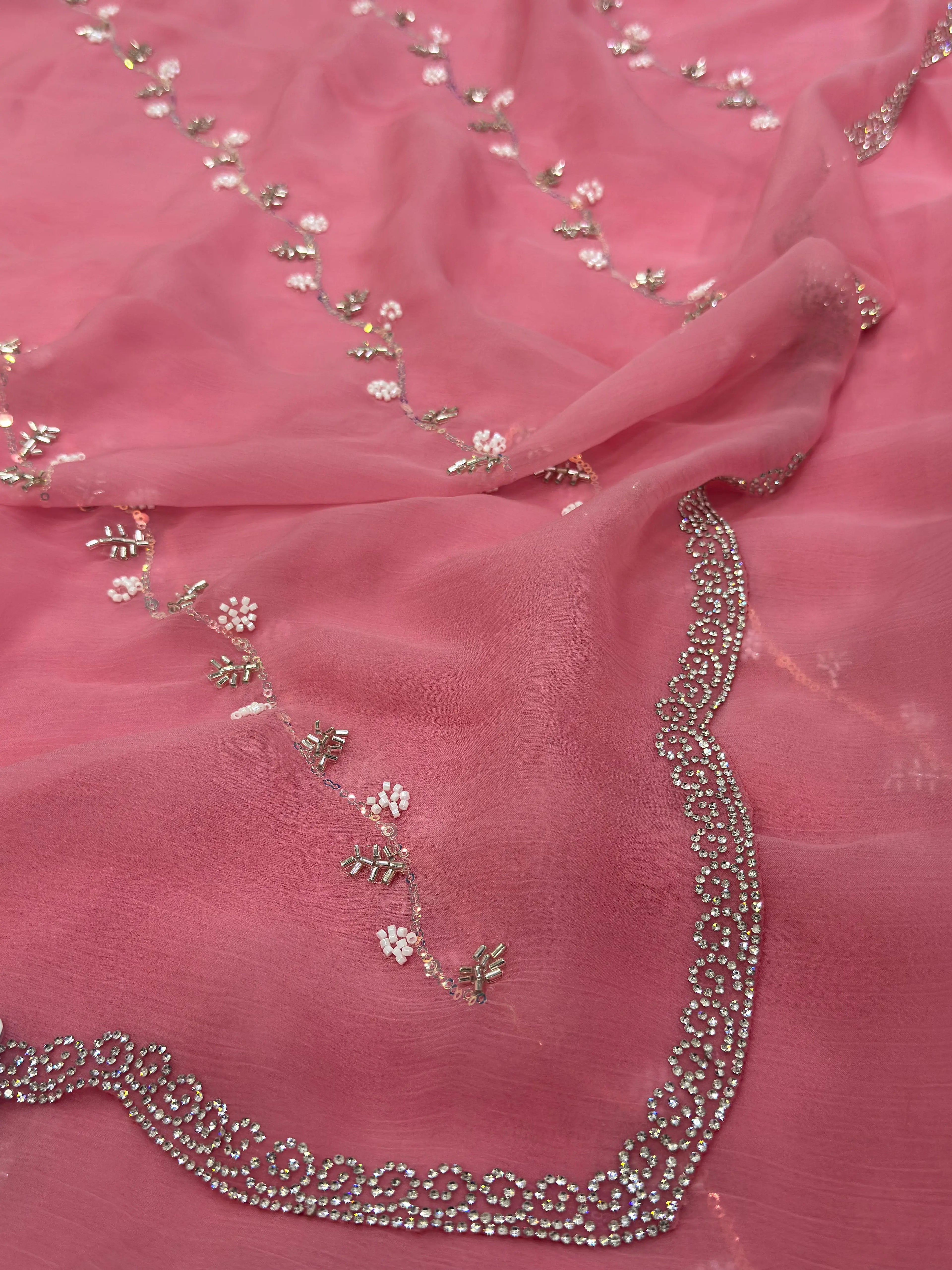 Pink fabric with floral and chain embellishments