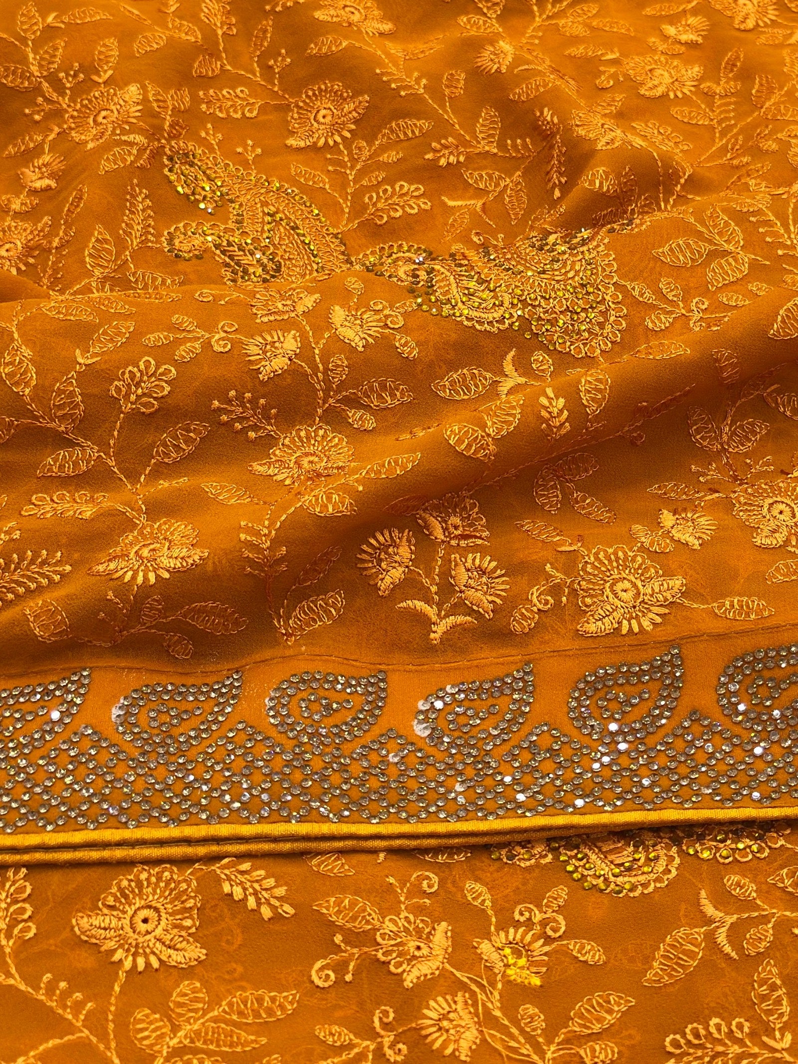 Orange fabric with intricate gold embroidery and patterns