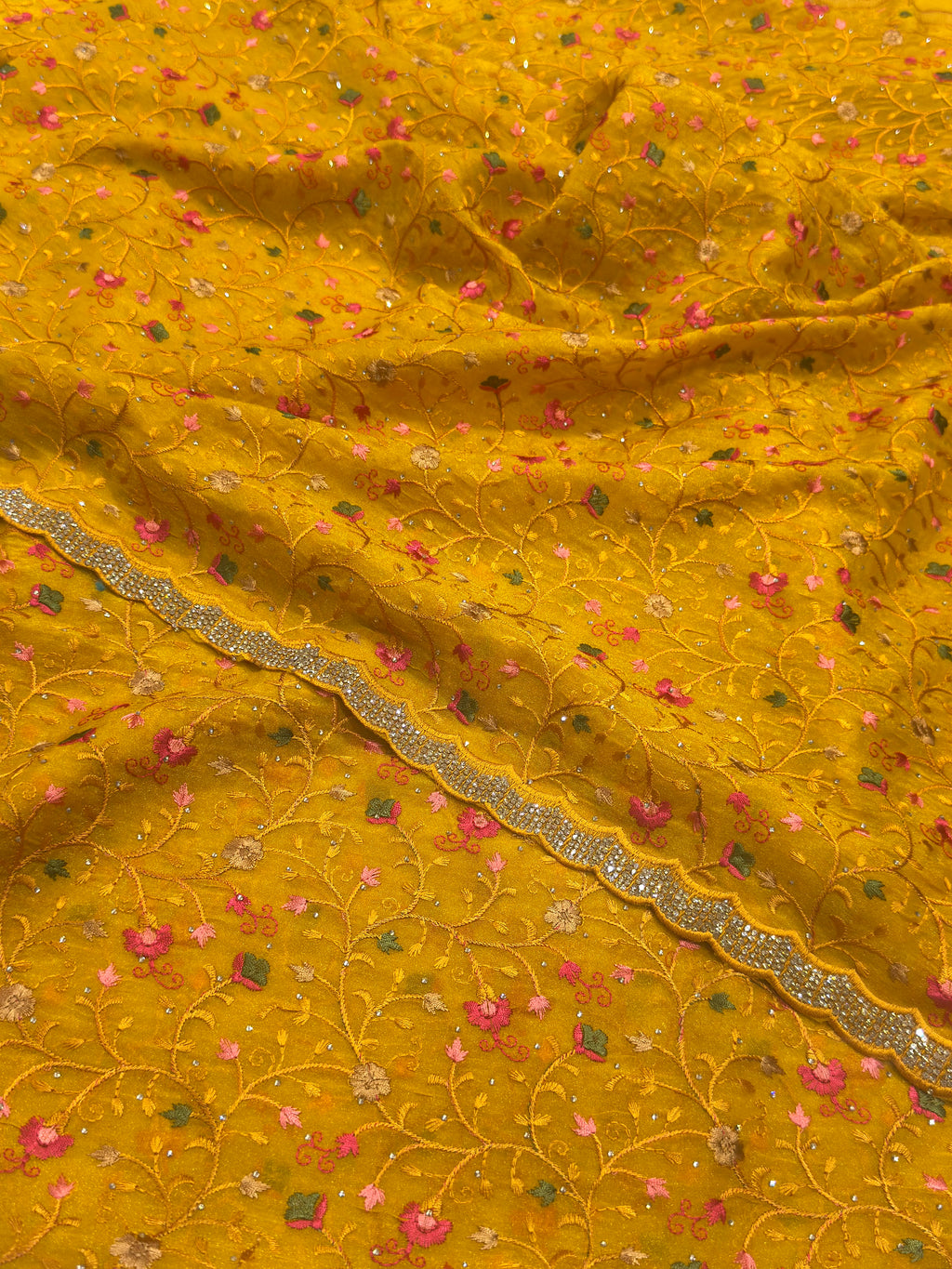 Mustard yellow fabric with floral patterns and a decorative border