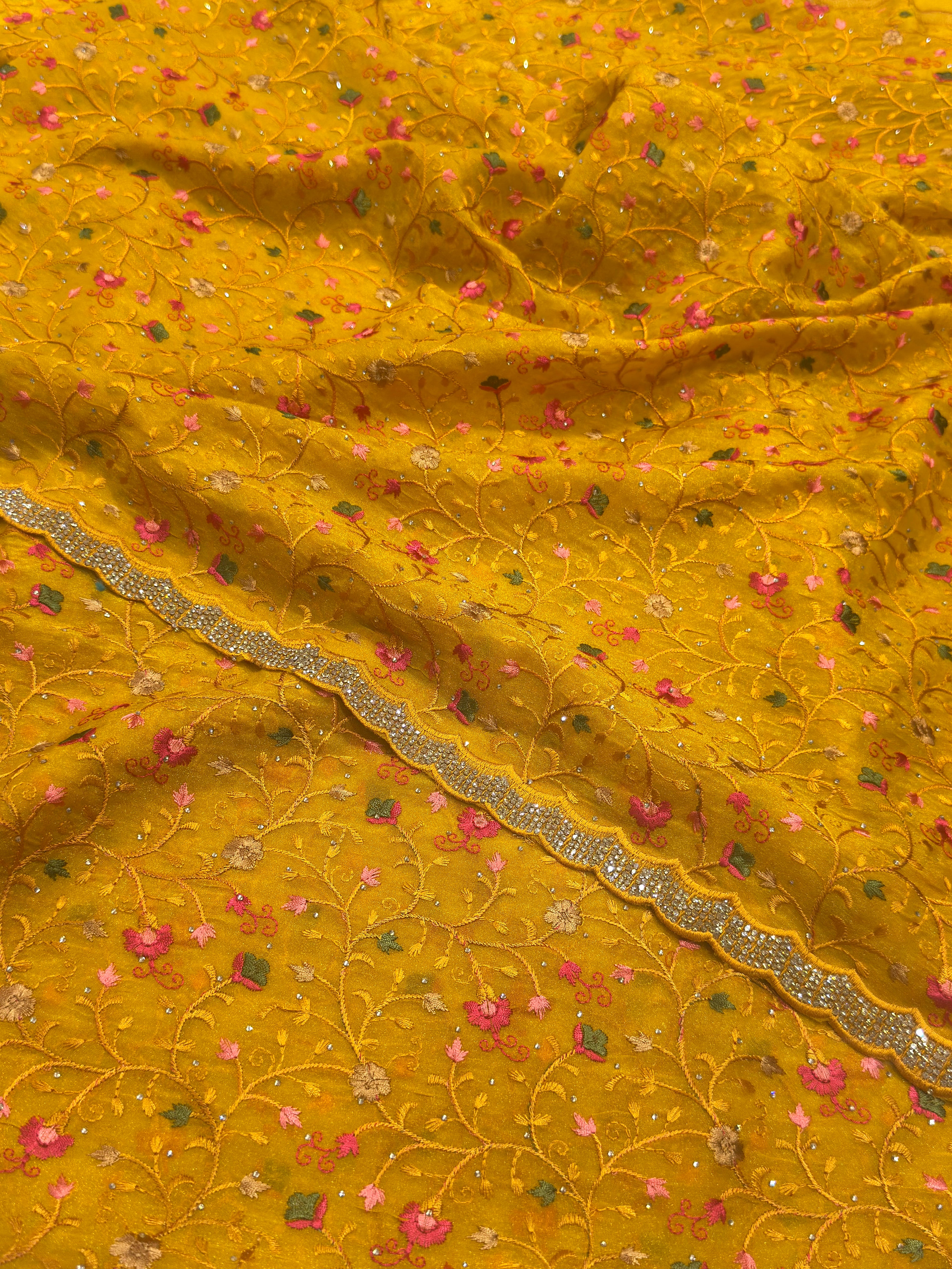 Mustard yellow fabric with floral patterns and a decorative border