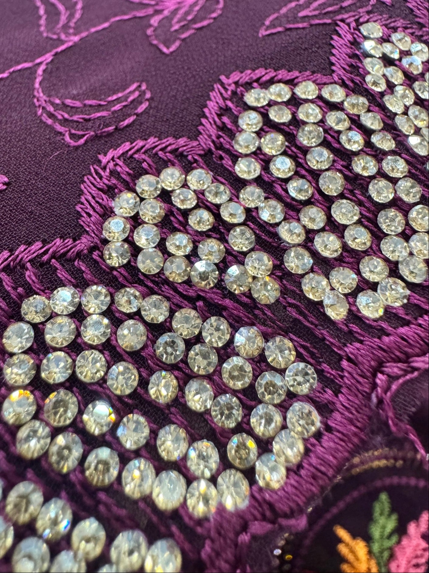 Close-up of a purple fabric with floral embroidery and crystal embellishments