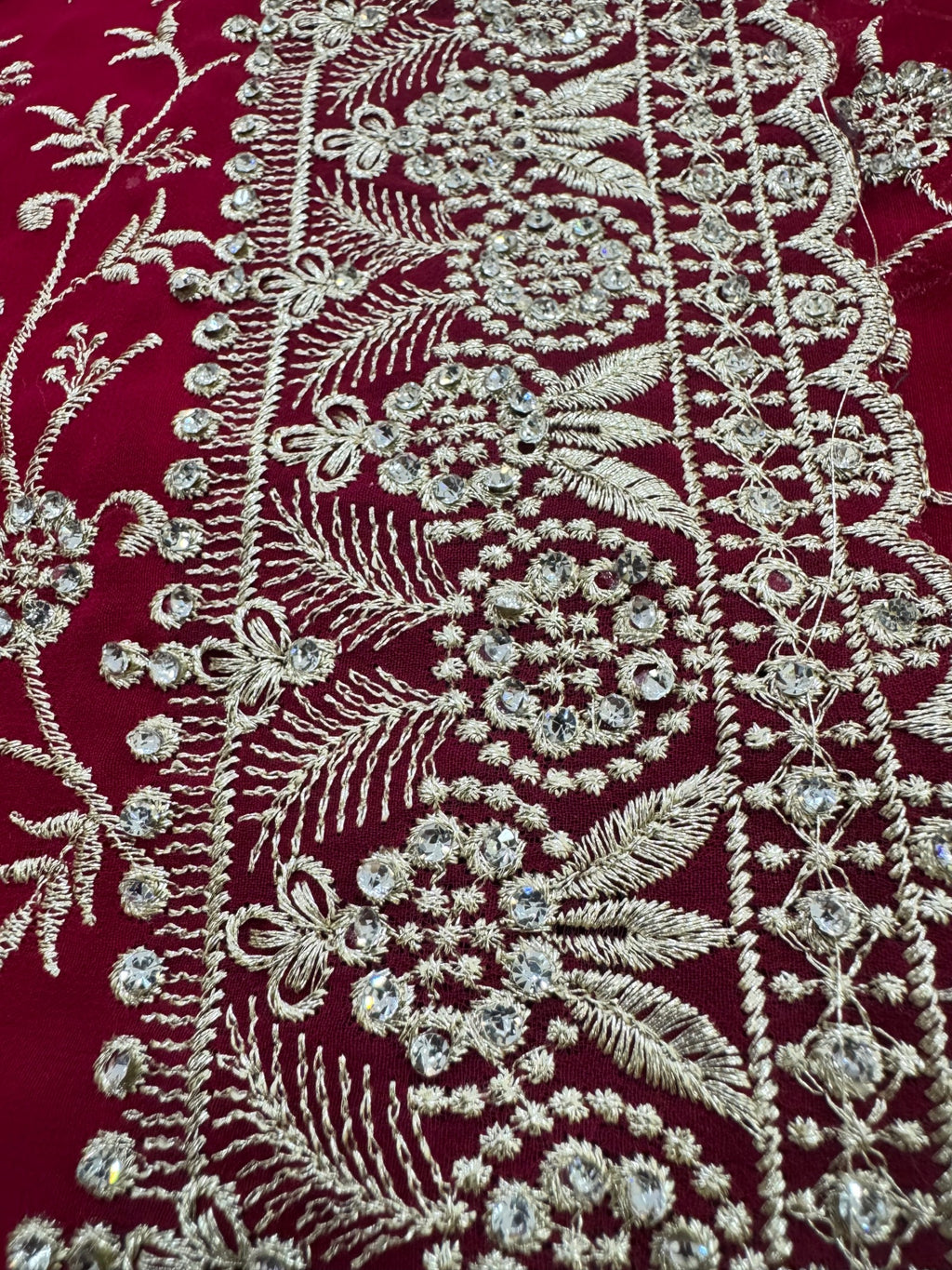 Close-up of intricate silver embroidery on a red fabric background