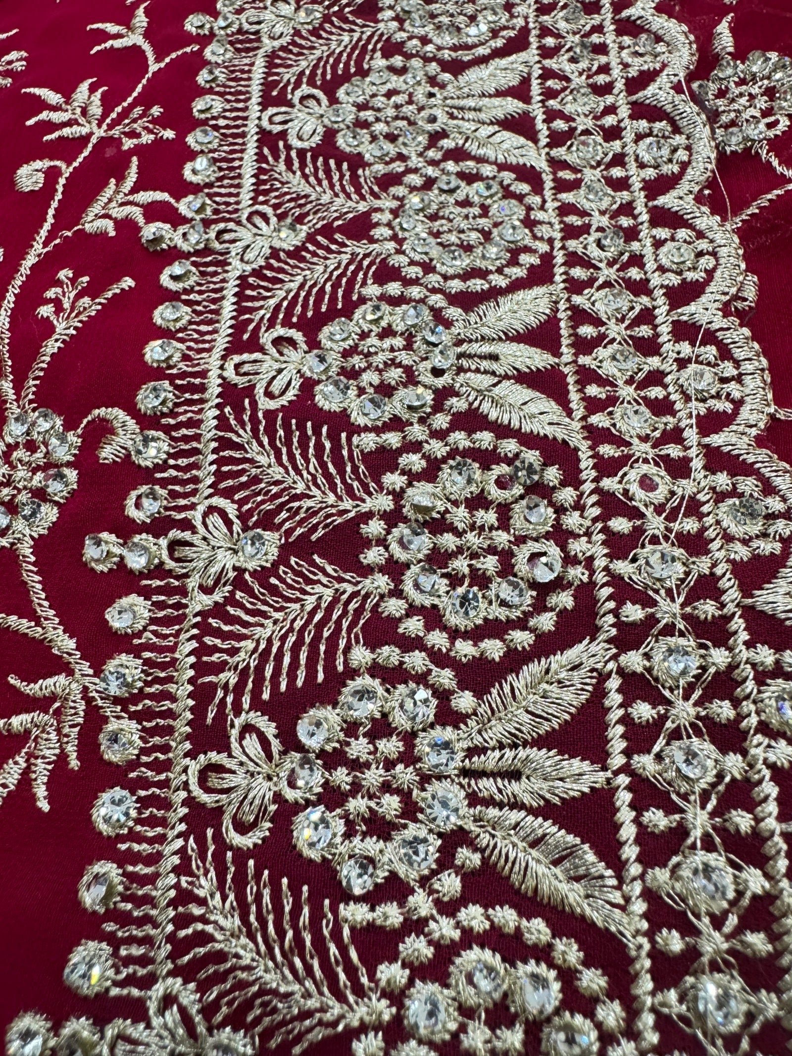 Close-up of intricate silver embroidery on a red fabric background