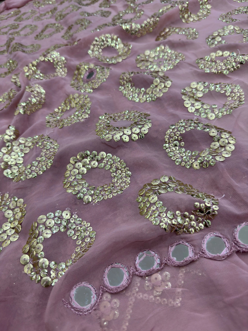 Close-up of pink fabric with gold sequin patterns