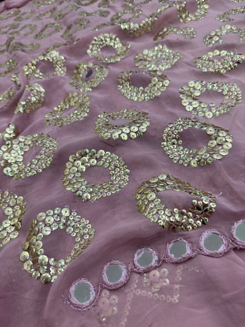 Close-up of pink fabric with gold sequin patterns
