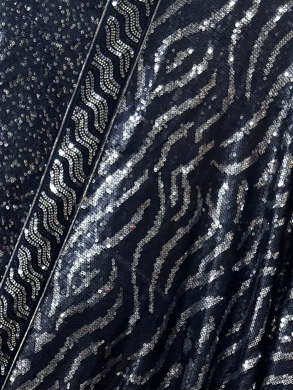 Close-up of a sequined fabric with a zebra pattern on a black background