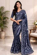 Woman wearing a blue patterned saree in an elegant indoor setting