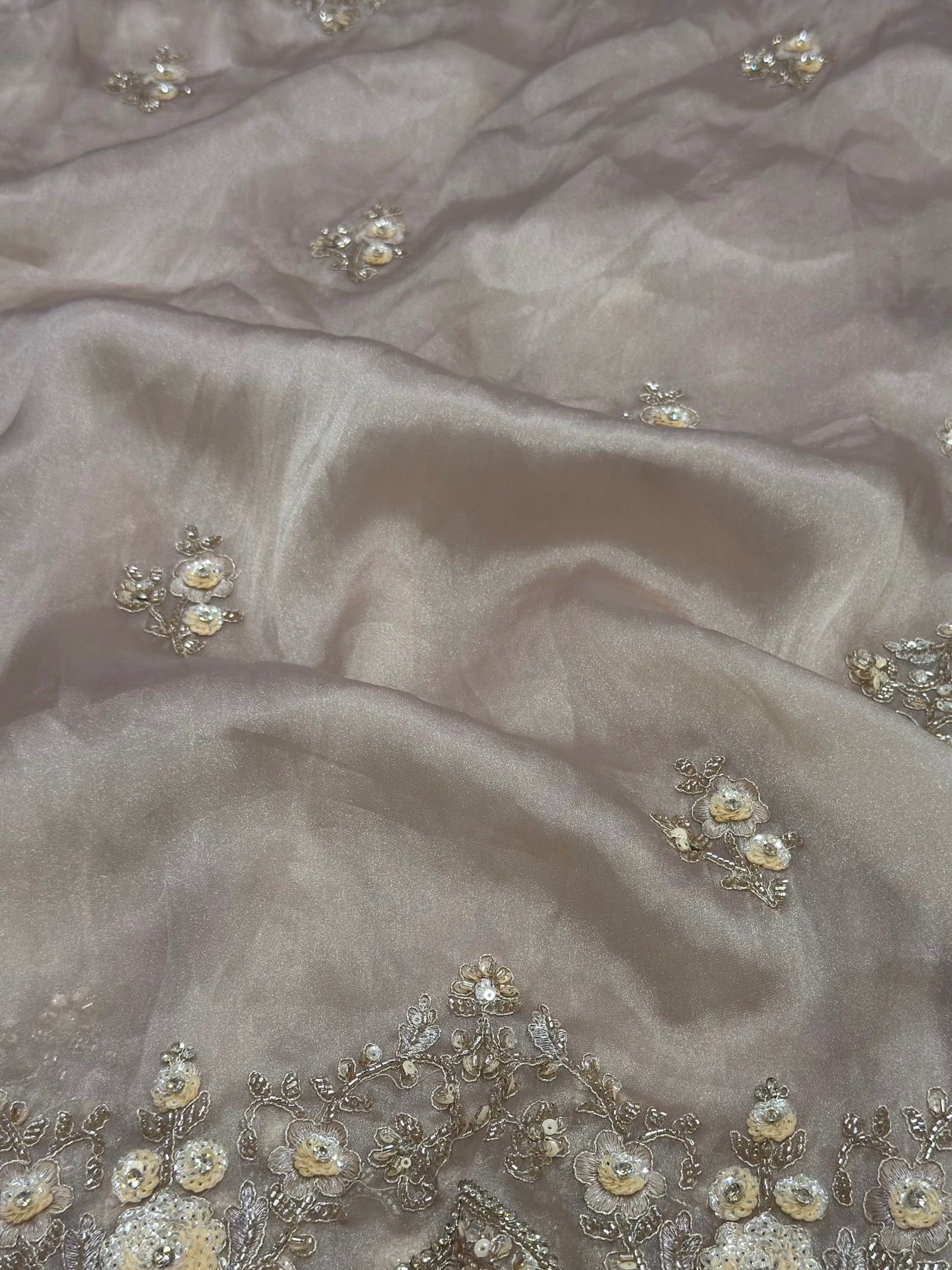 Close-up of beige fabric with floral embellishments