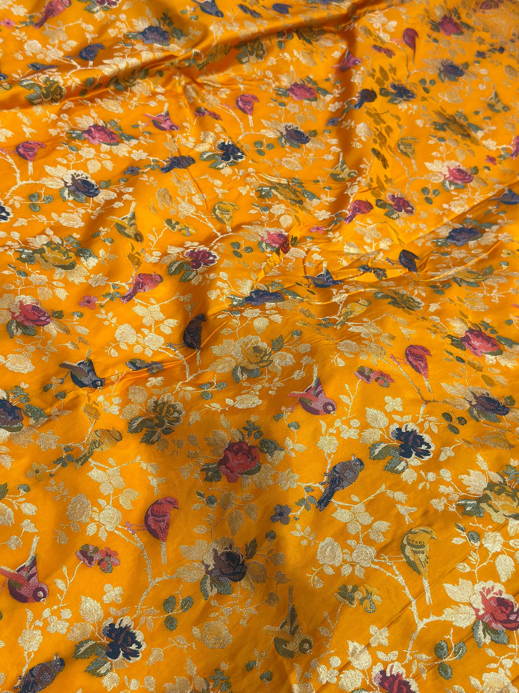 Floral patterned fabric with birds on a yellow background
