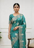 Woman wearing a teal saree with a white background