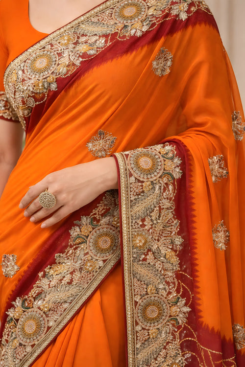 Orange saree with intricate gold and red embroidery