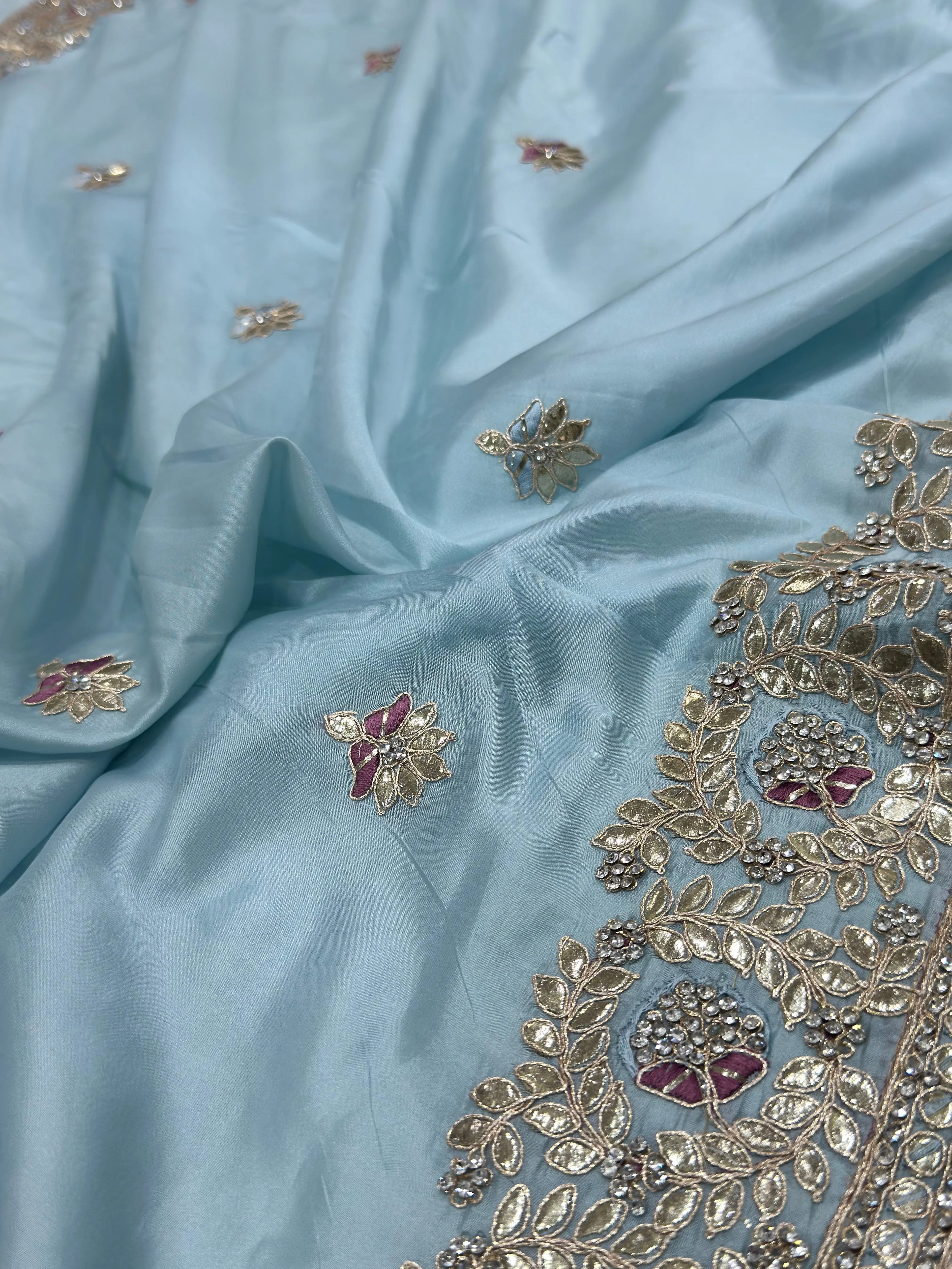 Light blue fabric with intricate gold and red embroidery