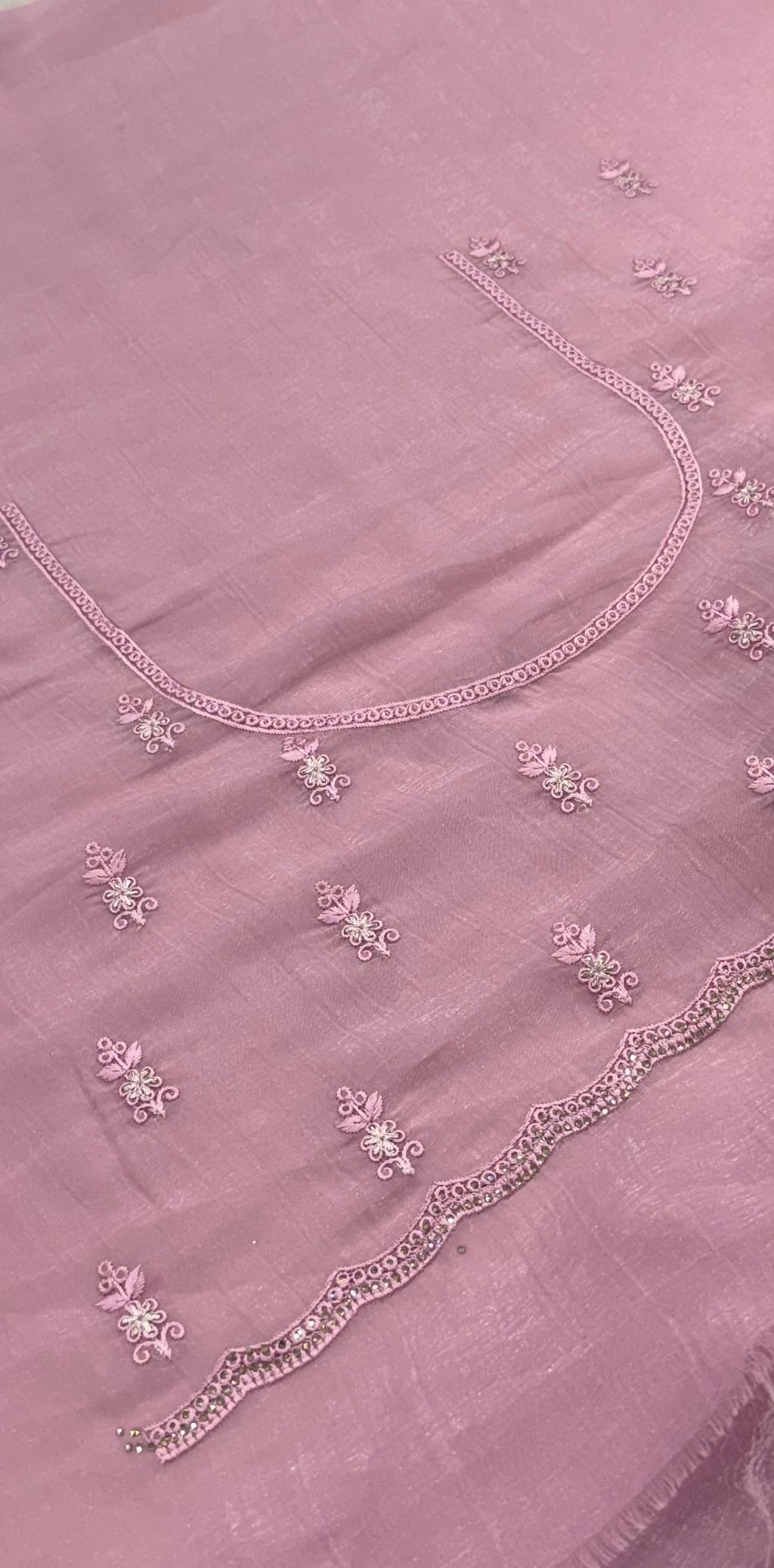 pink fabric with floral embroidery on a plain background
