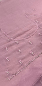pink fabric with floral embroidery on a plain background
