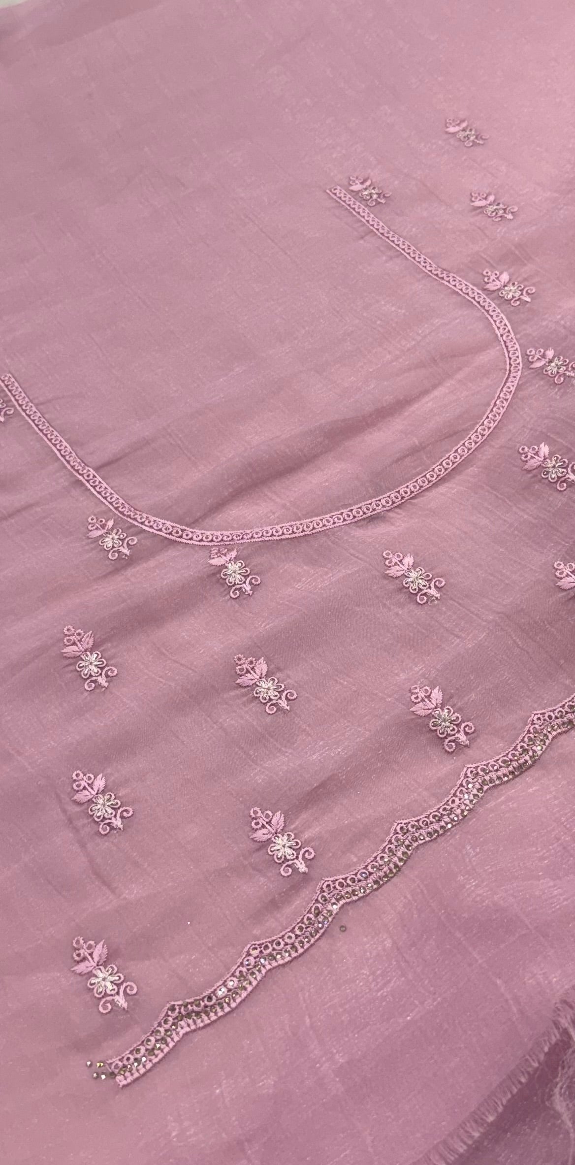 pink fabric with floral embroidery on a plain background