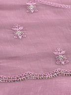 Close-up of a pink fabric with intricate floral embroidery