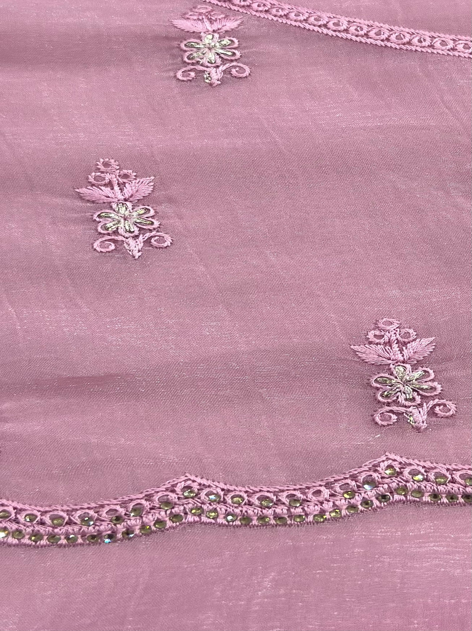 Close-up of a pink fabric with intricate floral embroidery