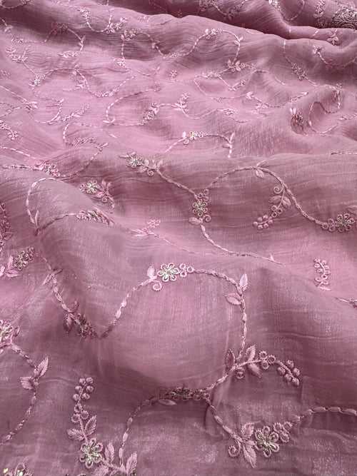 Close-up of pink fabric with floral embroidery
