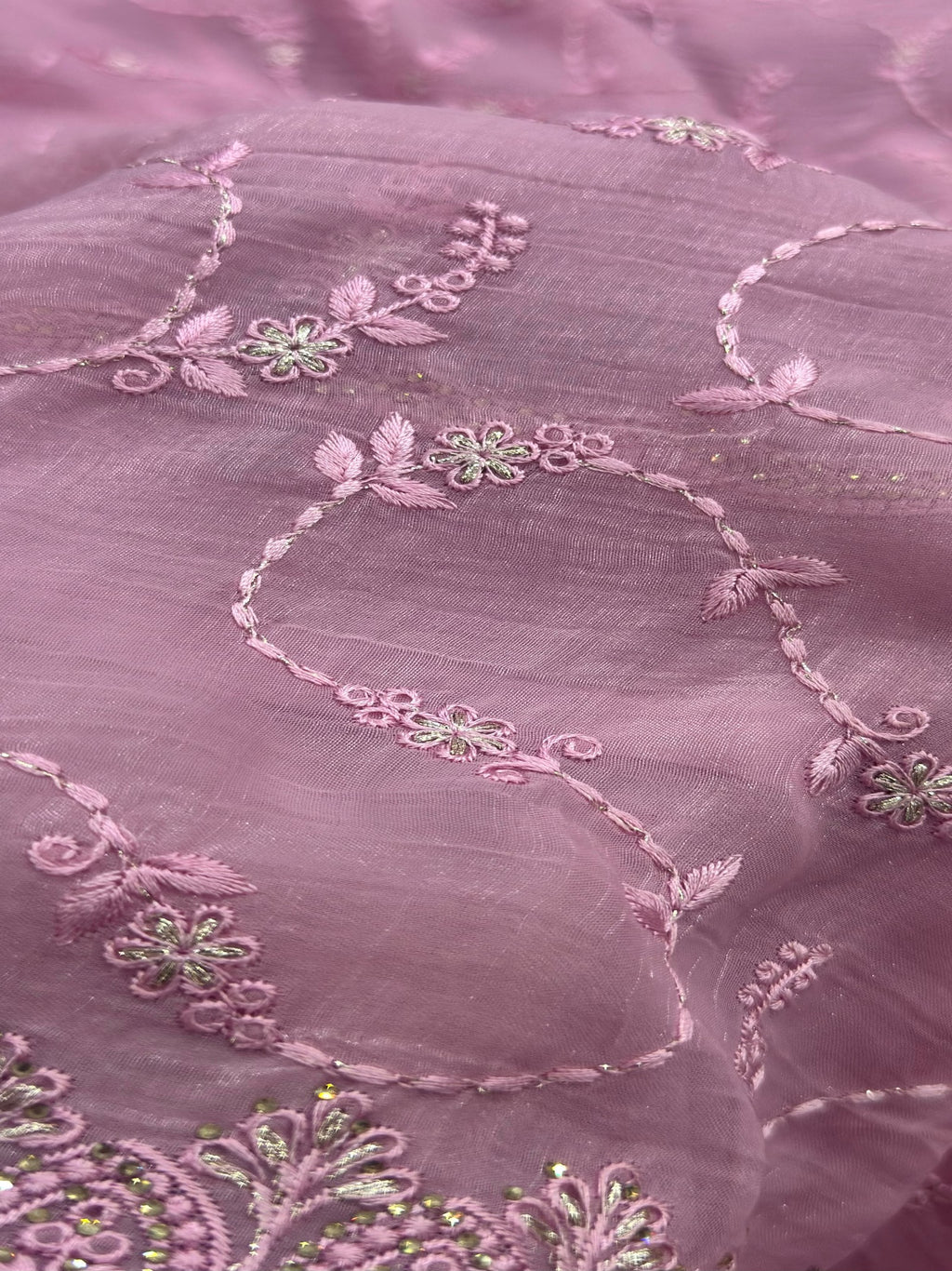 Close-up of pink fabric with floral embroidery