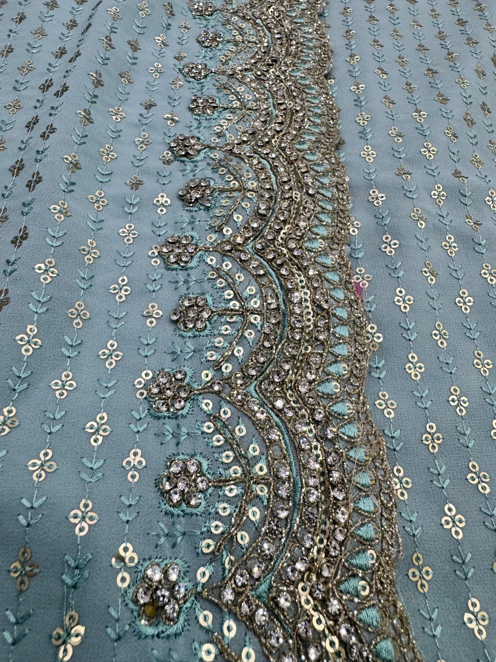 Close-up of intricate floral embroidery on a fabric with a blue background