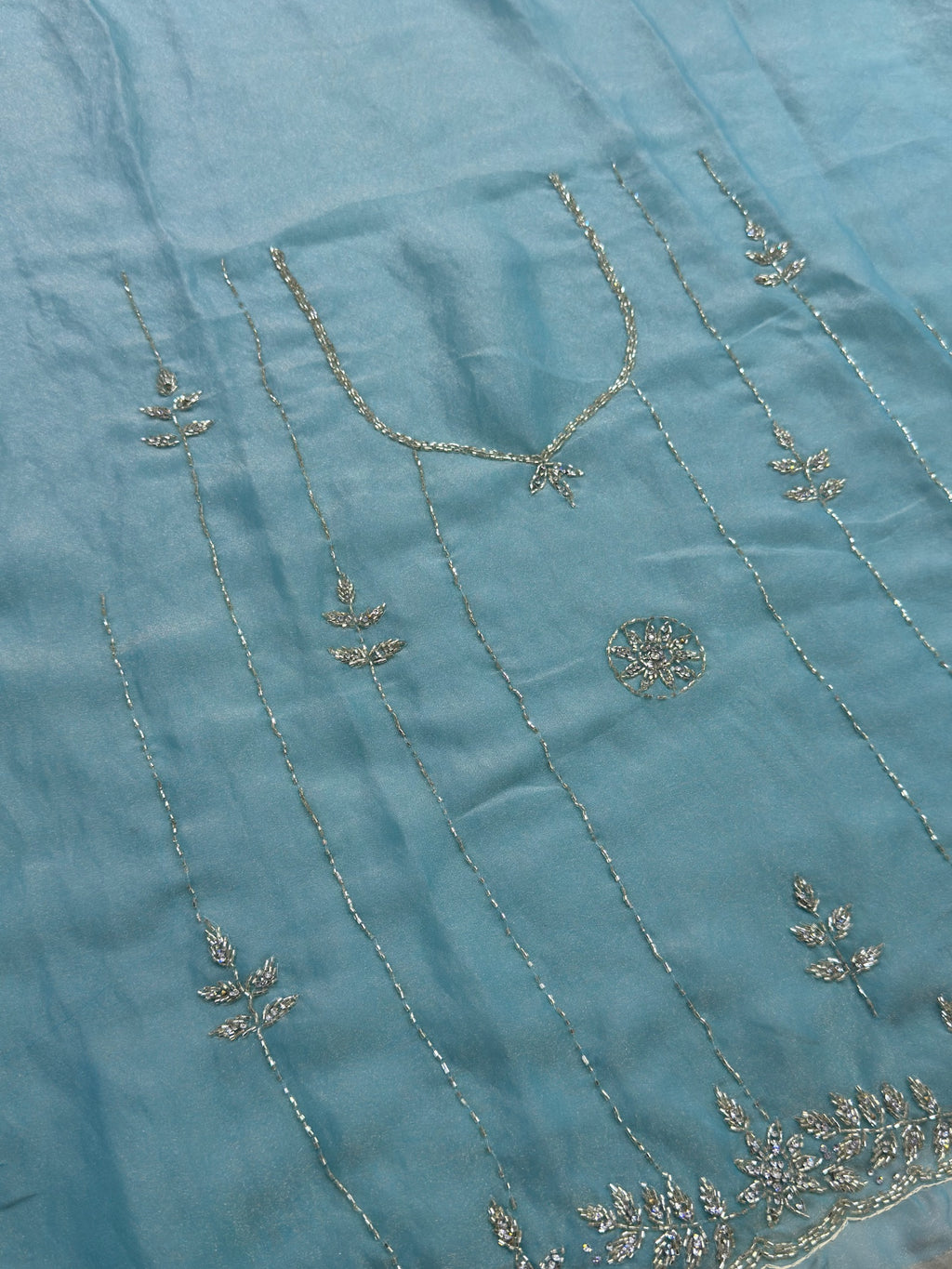 Close-up of embroidered fabric with floral patterns on a blue background
