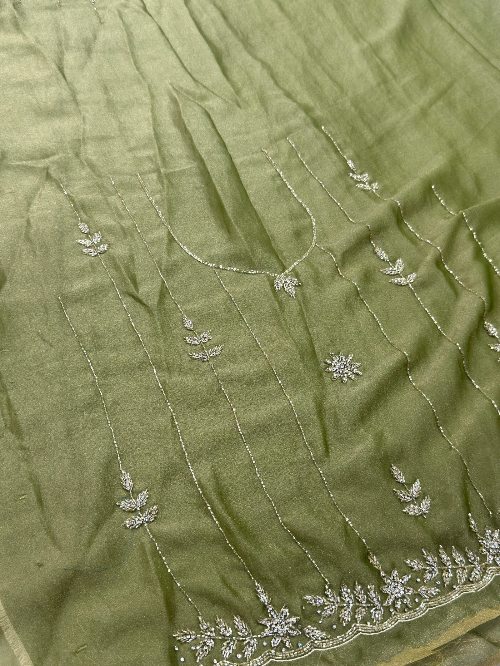 Green fabric with intricate silver embroidery