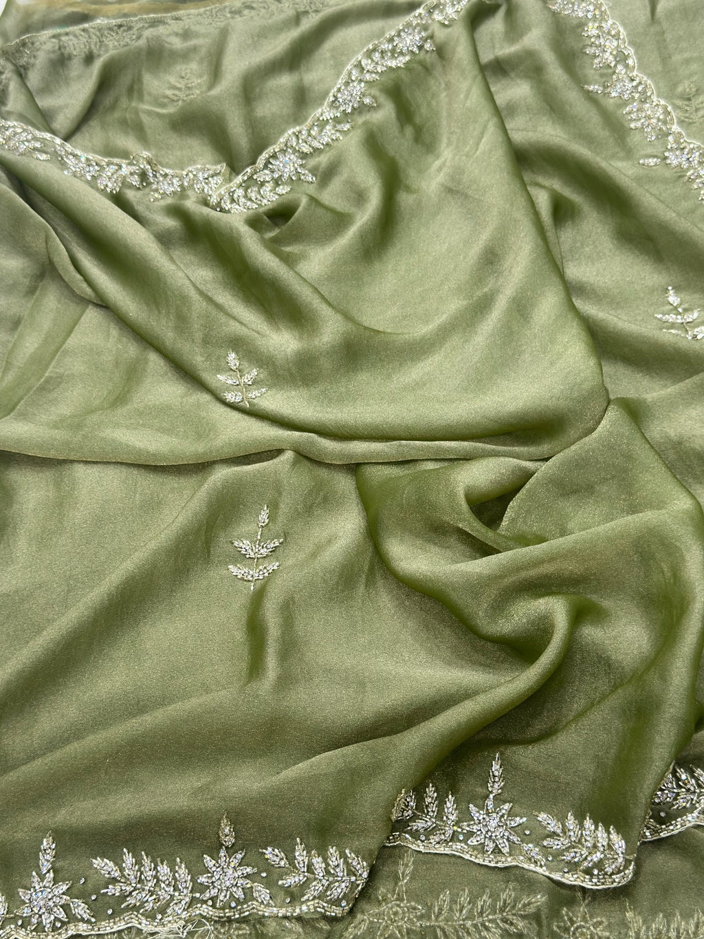 Green fabric with intricate silver embroidery