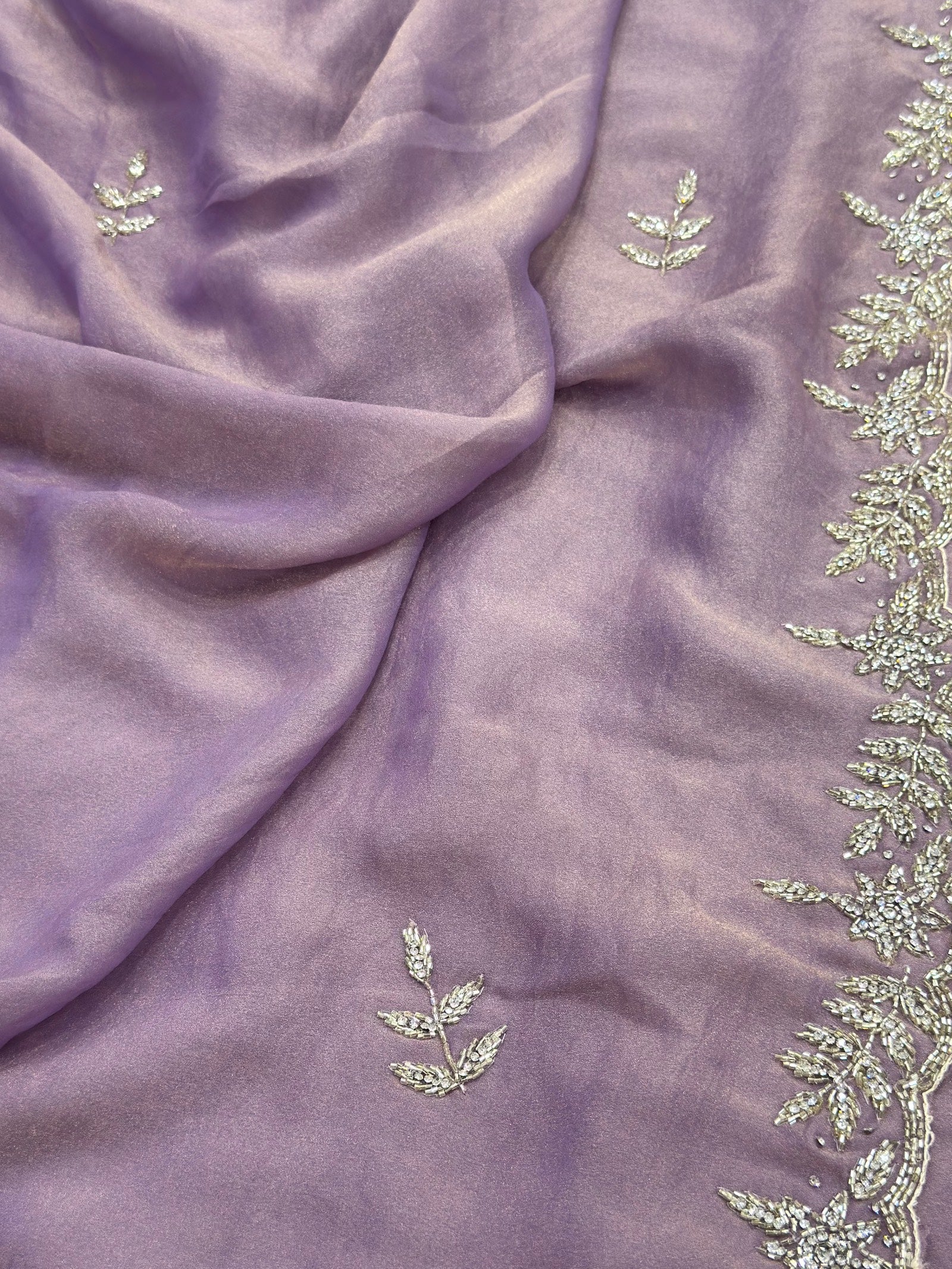 Purple fabric with green leaf-like embroidery
