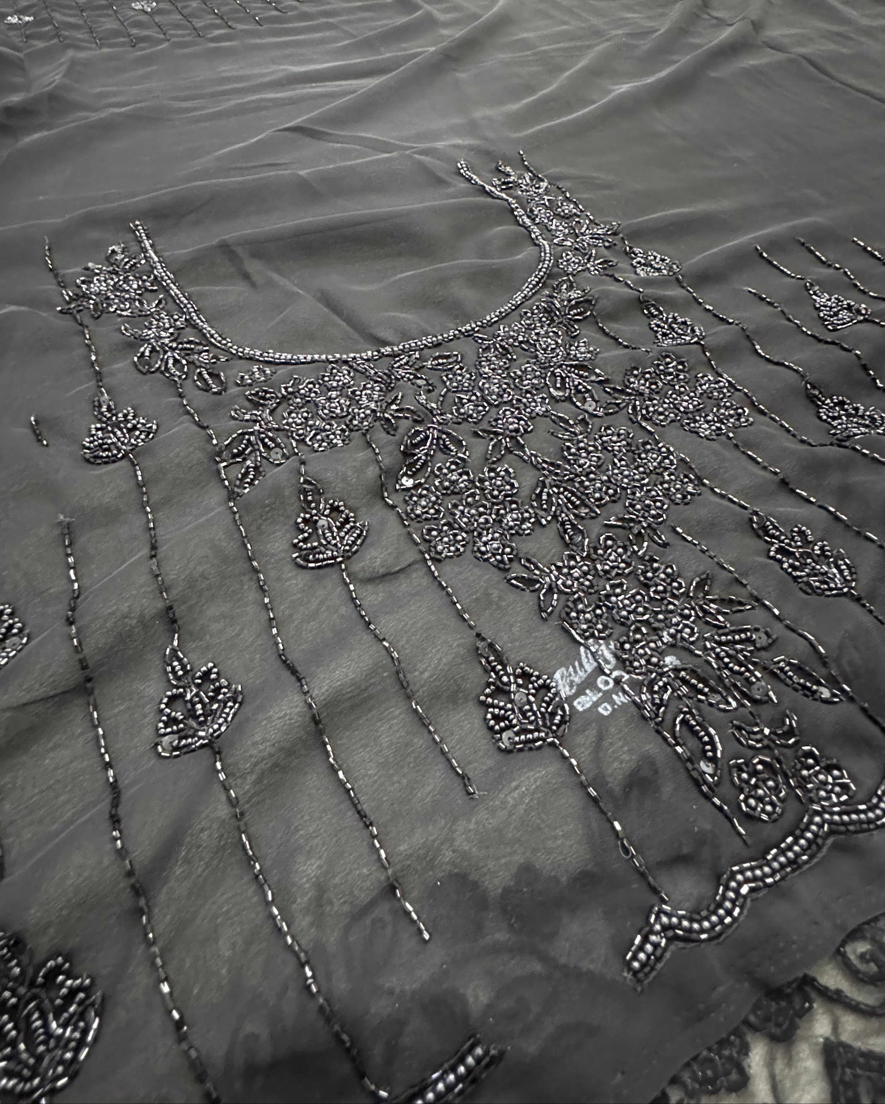 Close-up of a black embroidered garment with intricate patterns.