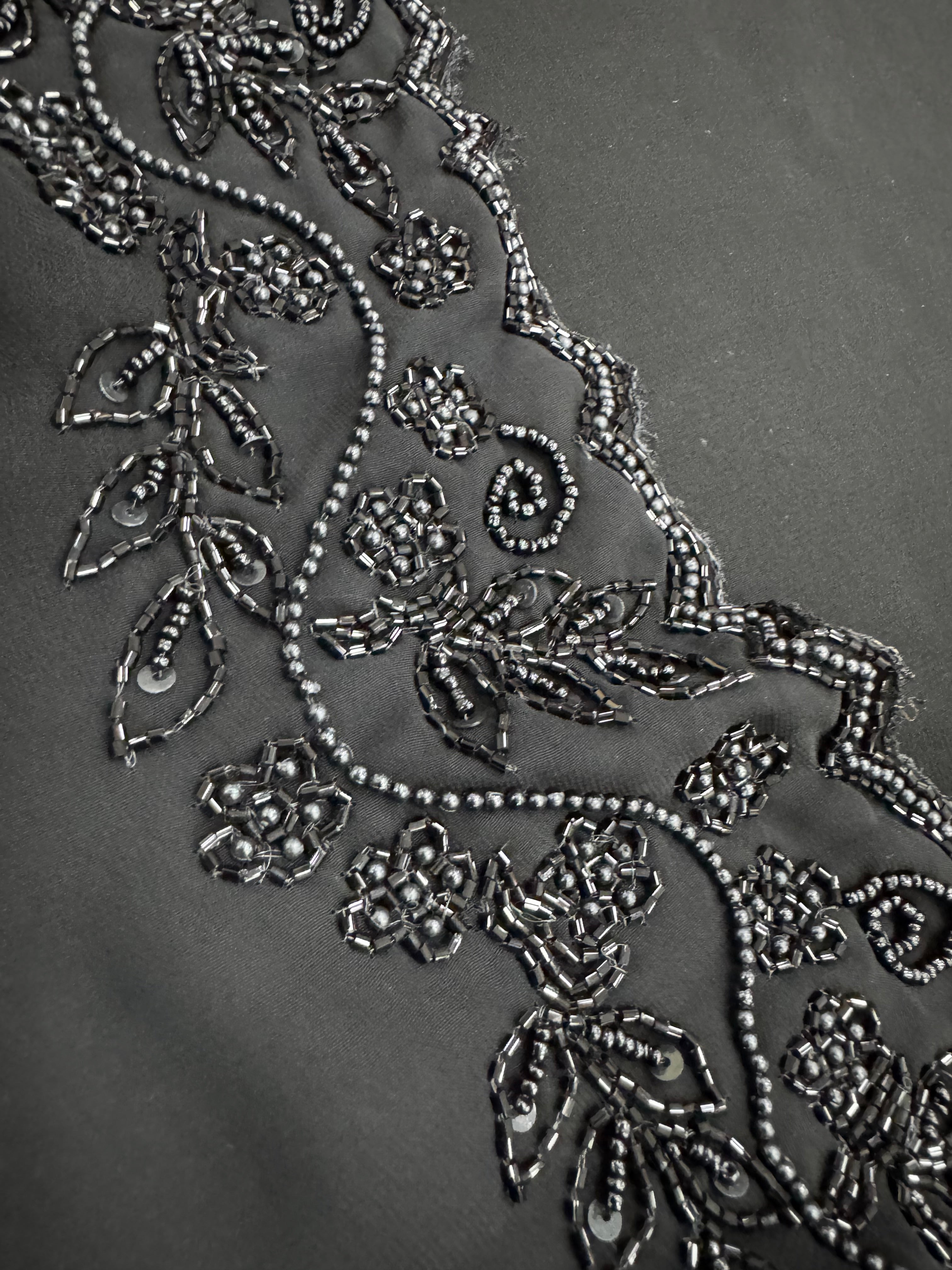 Close-up of intricate floral embroidery on a dark fabric background